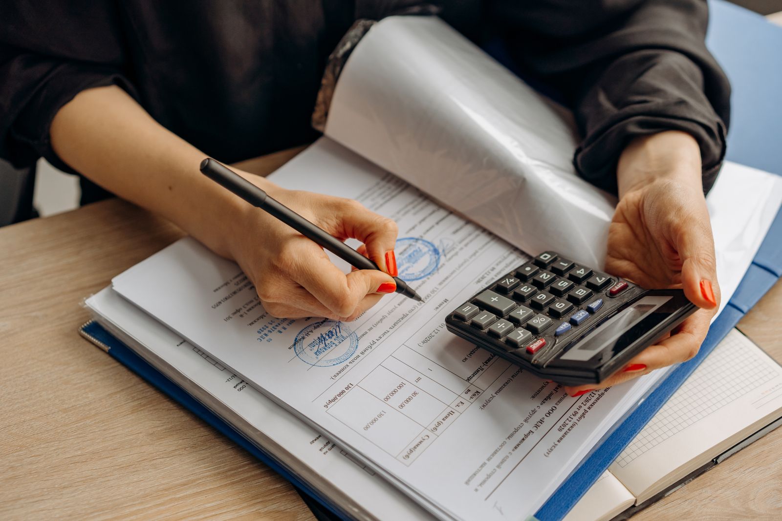 An accountant using a calculator and signing paperwork