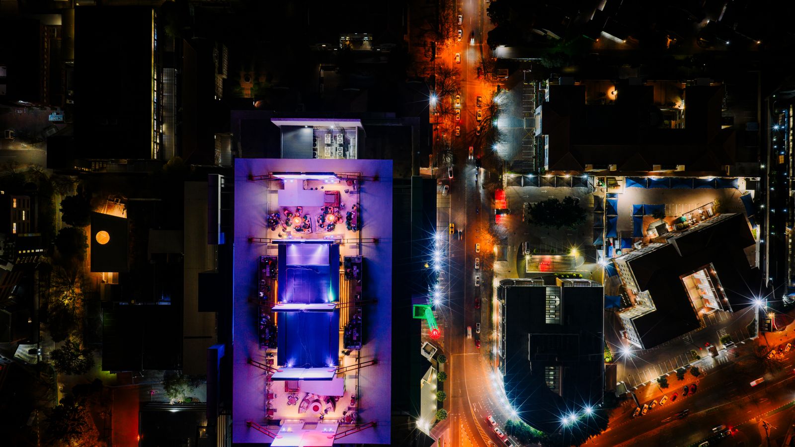 A rooftop bar with a city skyline at night