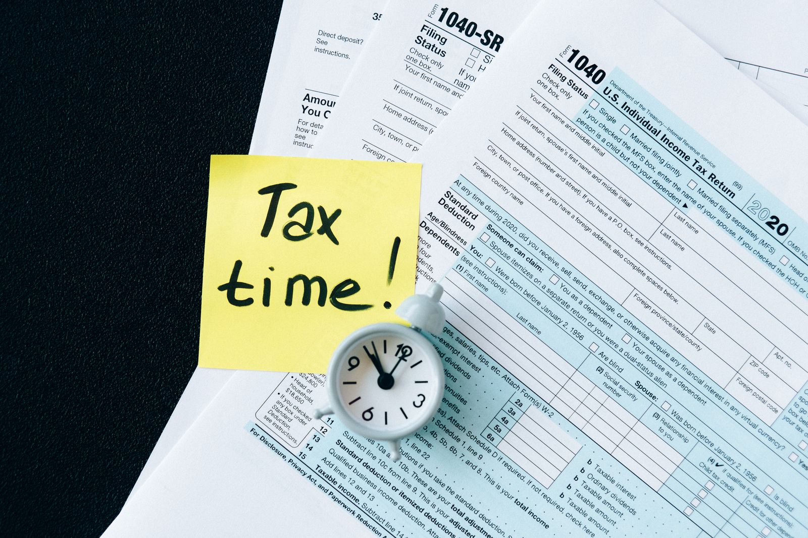 A stack of tax forms with a clock