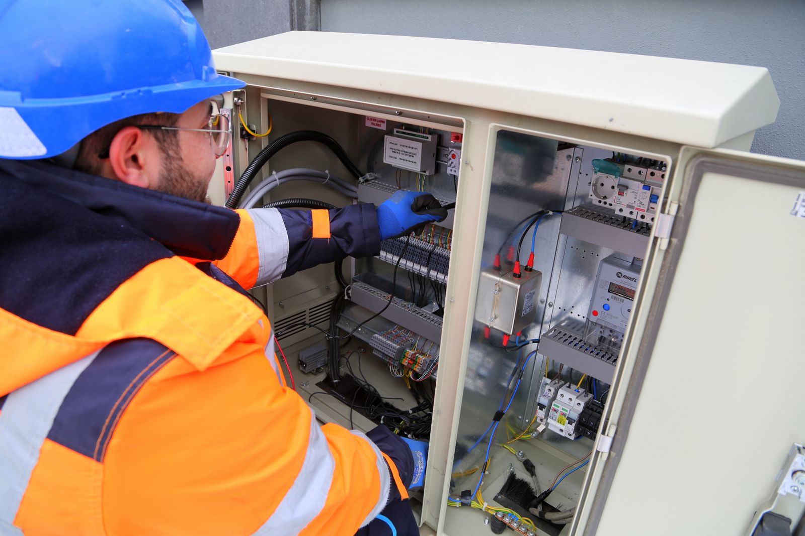 An electrician working on an electrical panel