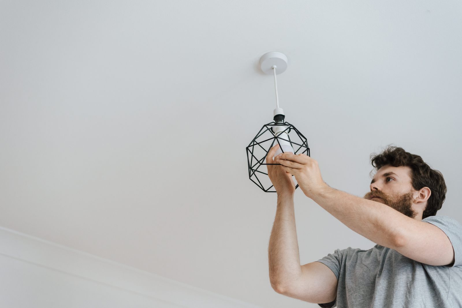 An electrician installing a light fixture