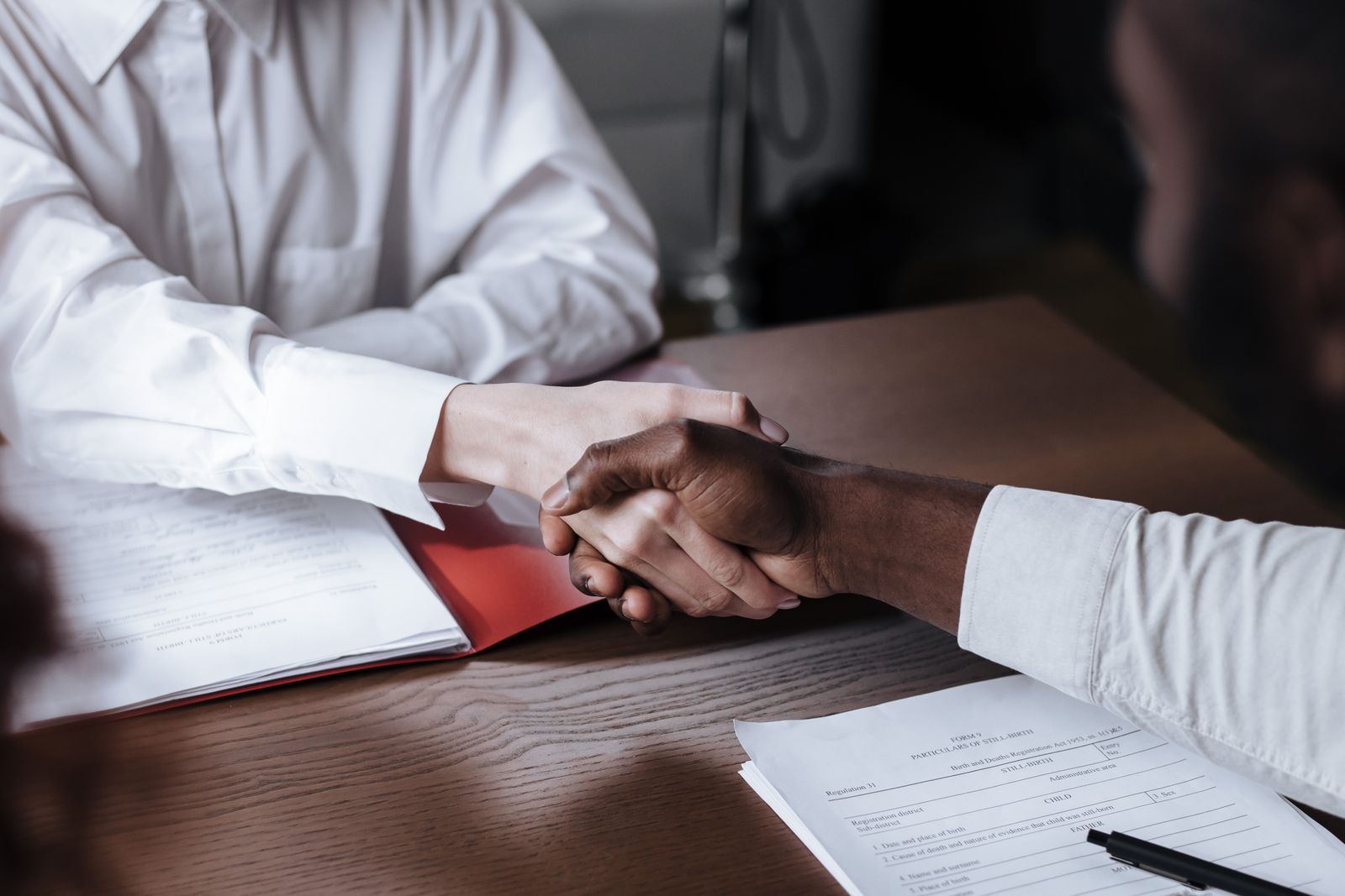 A business handshake over financial documents