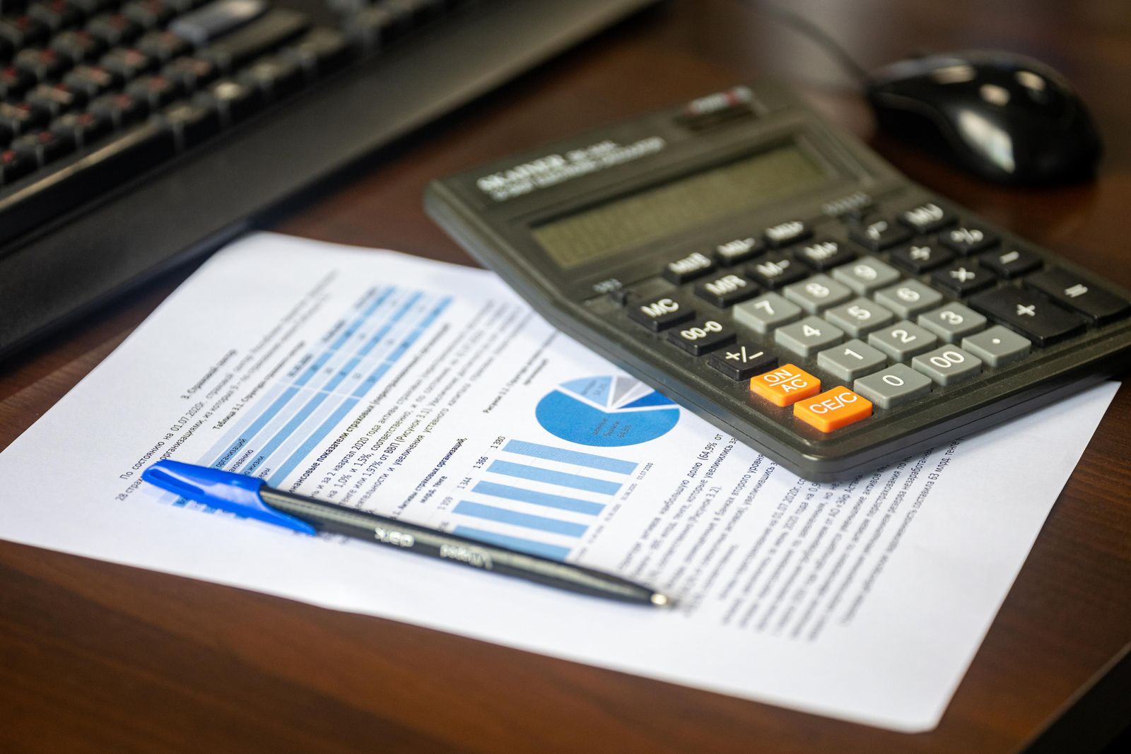 Desk with a calculator and financial report