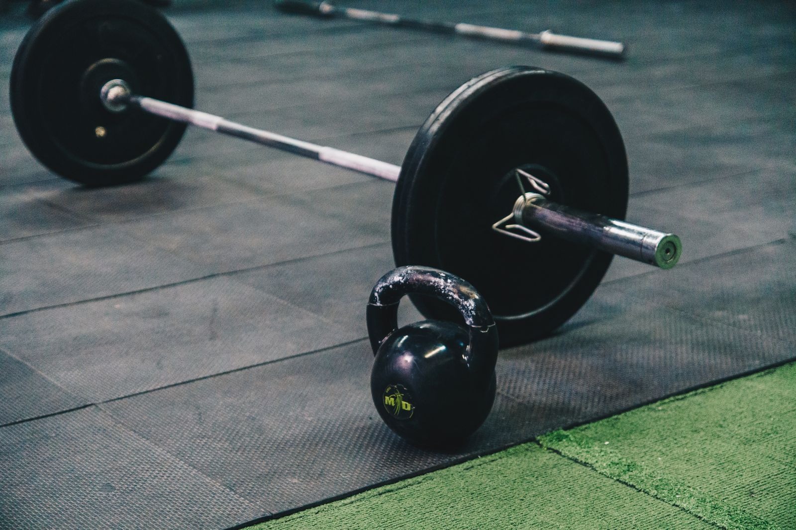 A gym floor with barbells and kettlebells