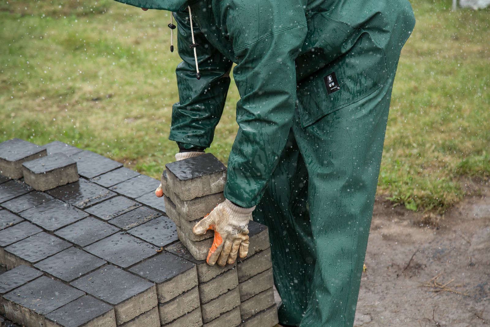 A landscaper installing a paver stone patio