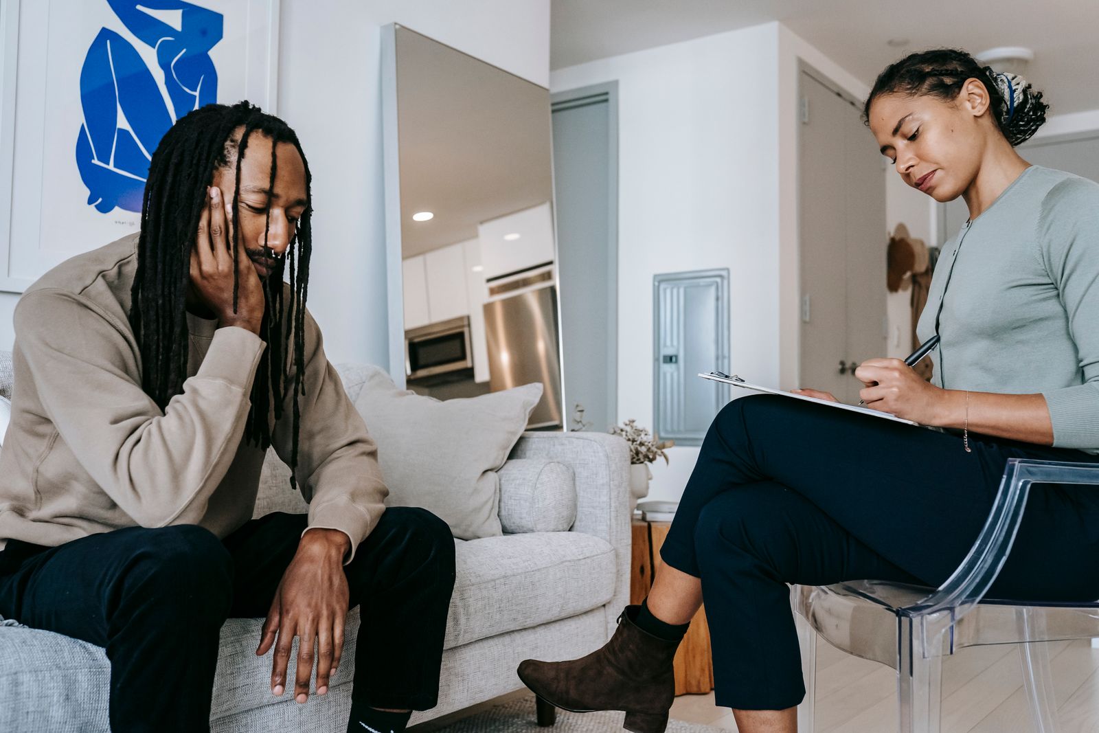 A clinician taking notes during a supportive conversation