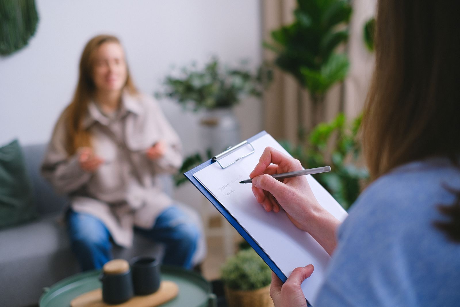 A therapist taking notes during a therapy session