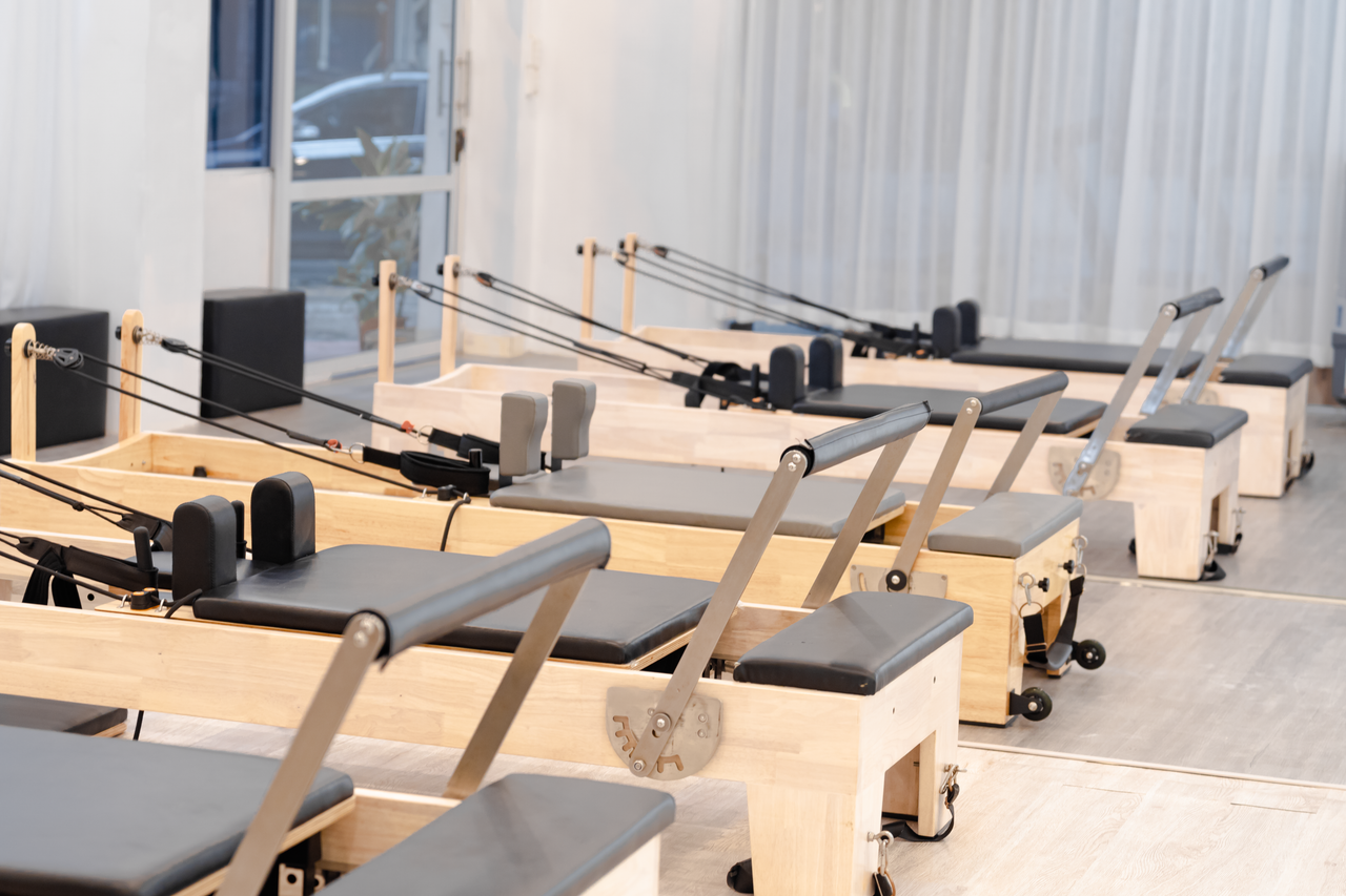 A contemporary Pilates studio with multiple reformers