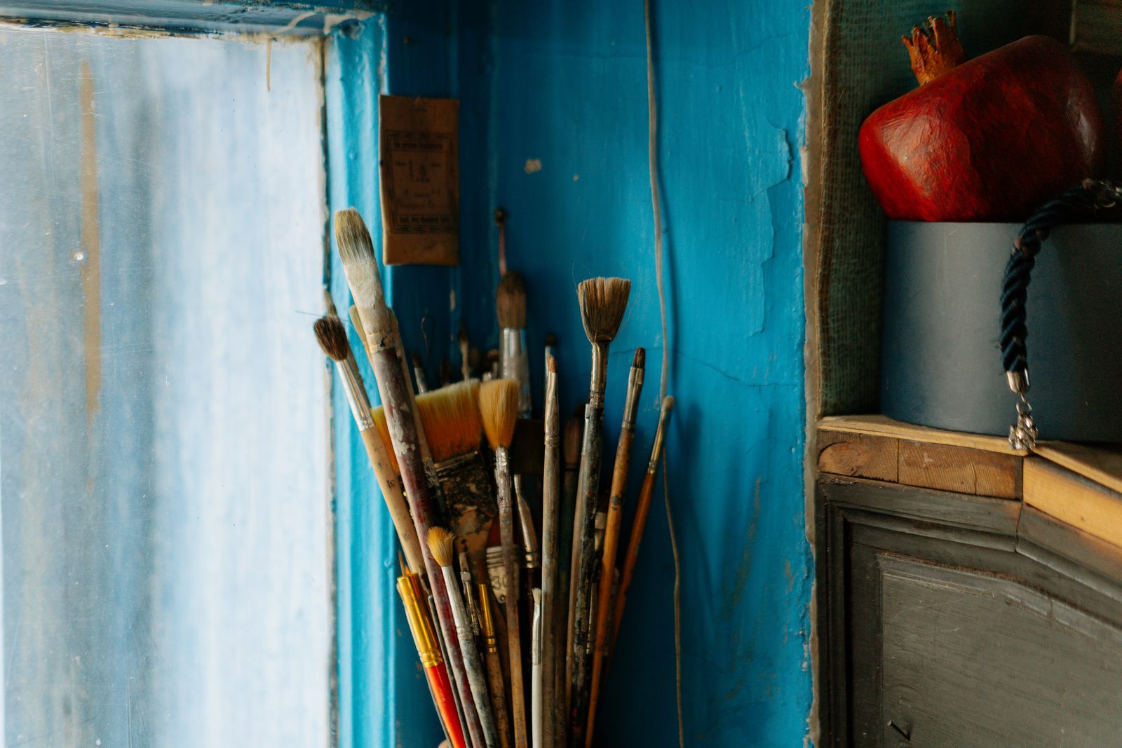 Paintbrushes against a painted wall