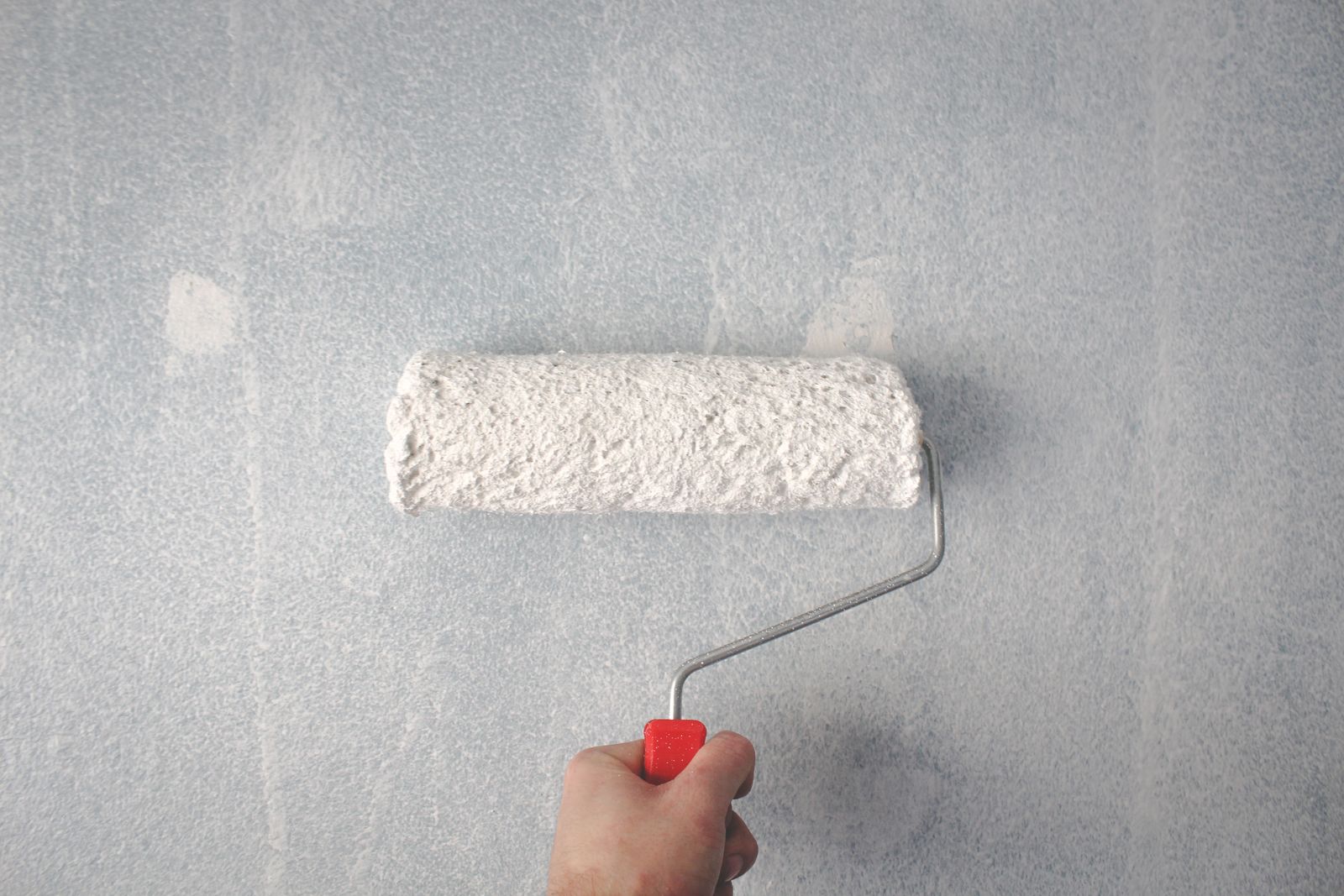 A painter applying paint with a roller