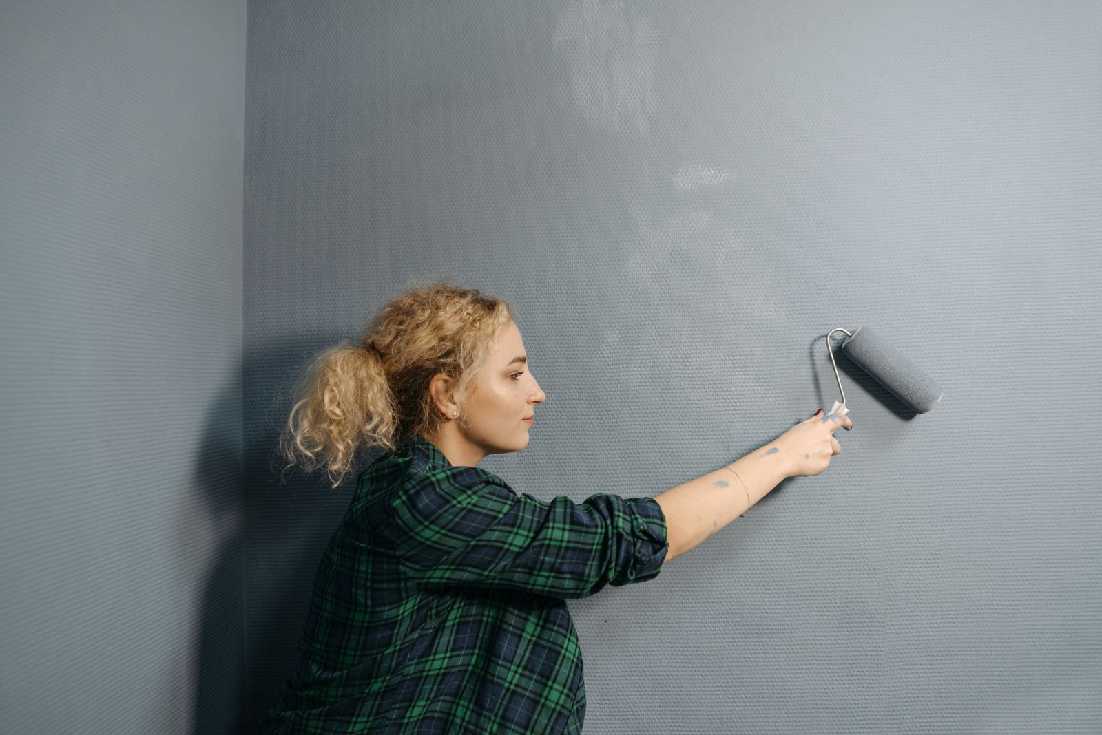 A painter rolling paint onto an interior wall