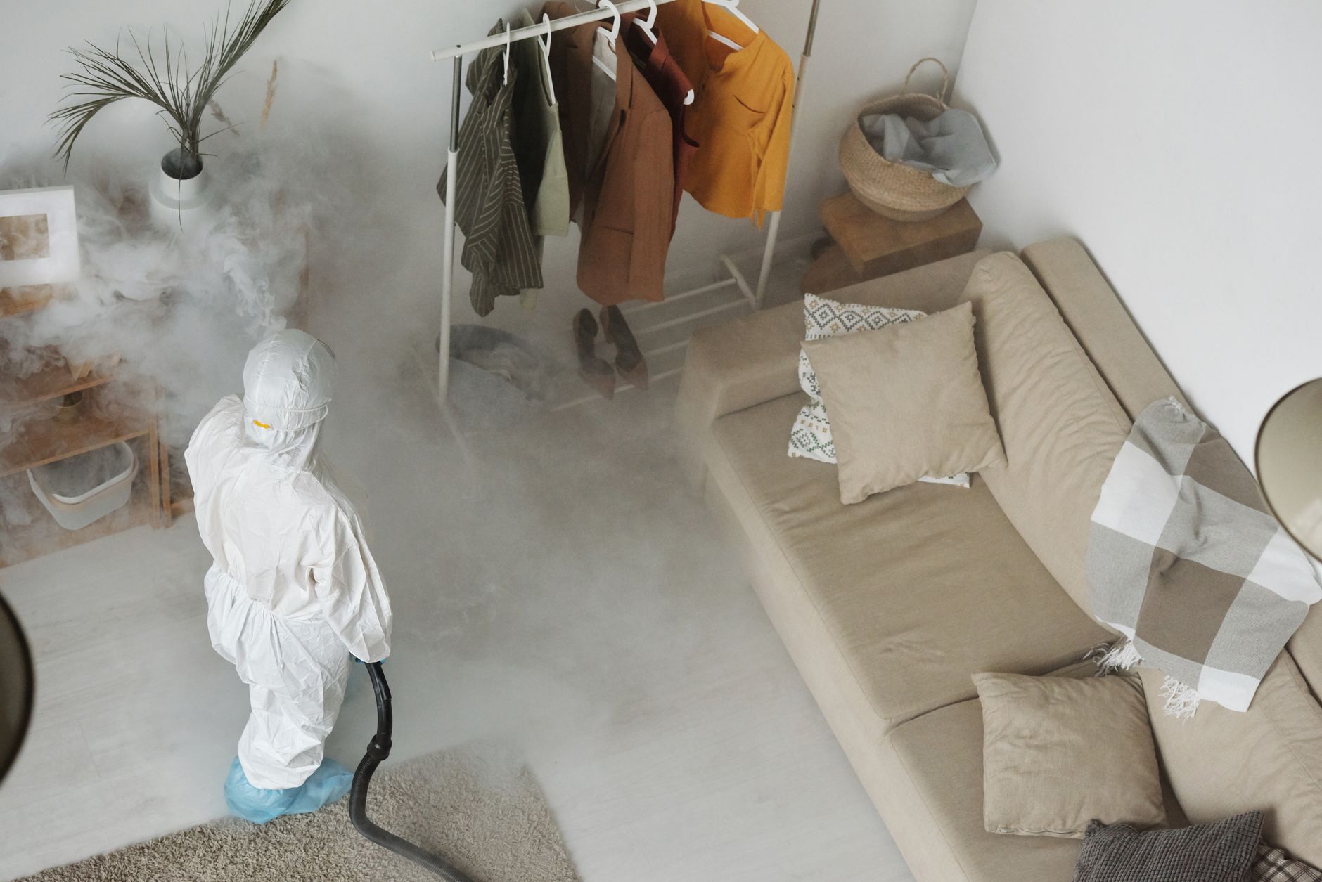 A pest control professional treating a room baseboard
