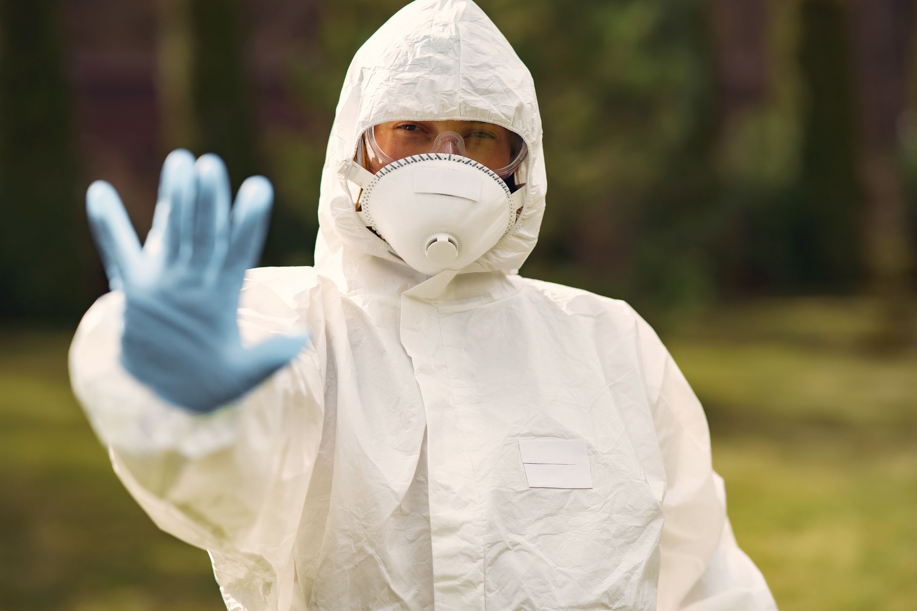 A pest control technician in protective equipment