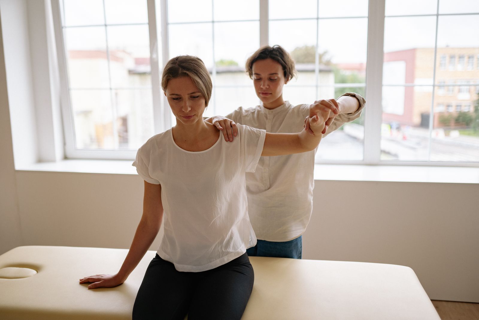 A therapist assisting a patient with stretching during a physical therapy session