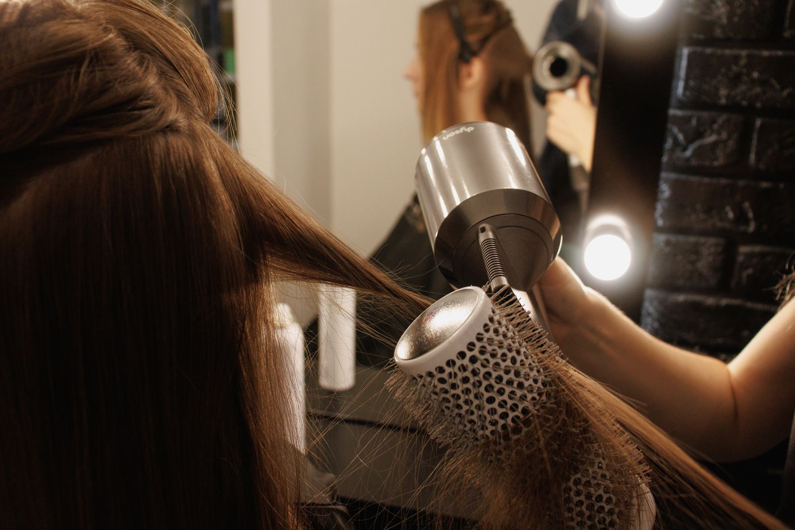 A stylist blow-drying a client's hair