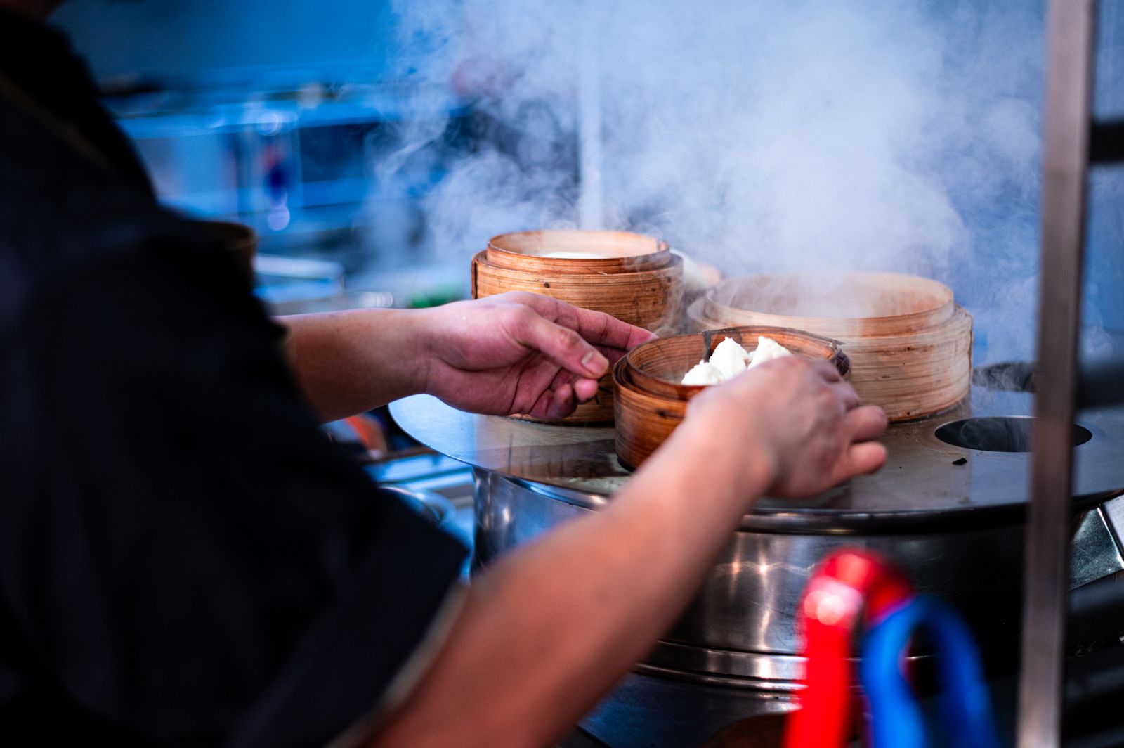 Chef preparing steaming dim sum baskets
